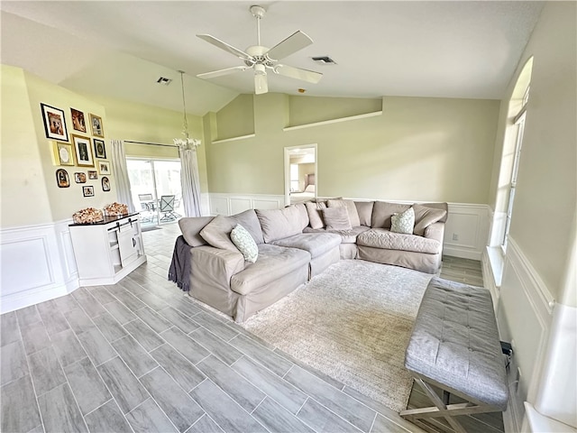 living room with high vaulted ceiling, light wood-type flooring, and ceiling fan with notable chandelier