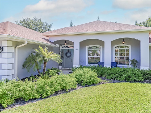 view of exterior entry featuring a yard