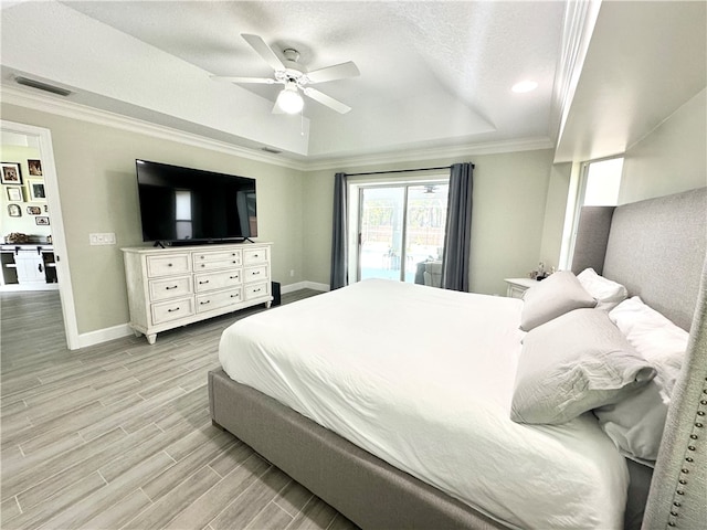 bedroom with access to outside, light hardwood / wood-style floors, ceiling fan, a raised ceiling, and crown molding