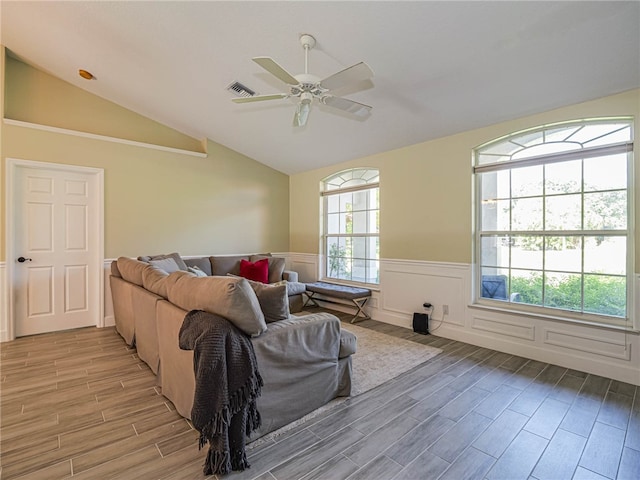 living room with light hardwood / wood-style floors, ceiling fan, and vaulted ceiling