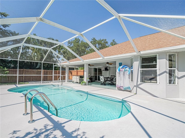 view of swimming pool with ceiling fan, a lanai, and a patio