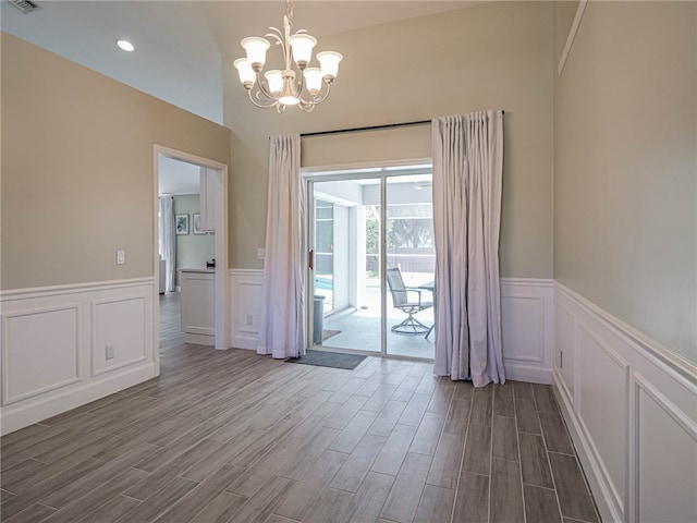 unfurnished dining area with hardwood / wood-style flooring and an inviting chandelier