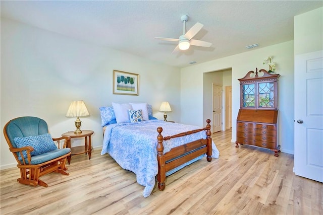 bedroom with visible vents, light wood-style floors, ceiling fan, and a textured ceiling