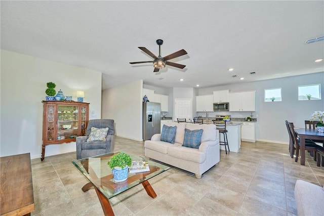 living area with visible vents, recessed lighting, baseboards, and ceiling fan