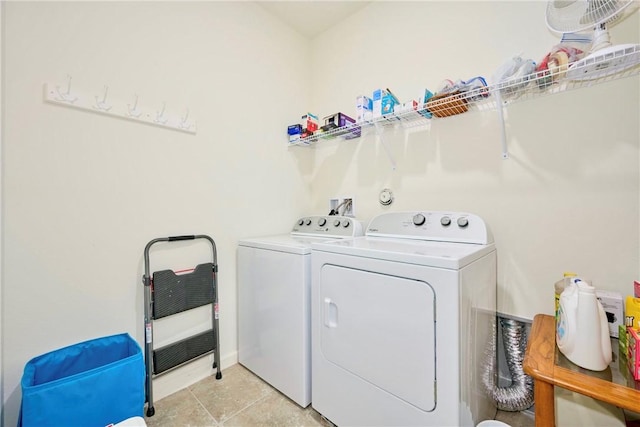 washroom featuring laundry area, light tile patterned flooring, and washing machine and dryer