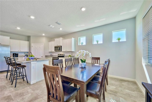 dining space with recessed lighting, visible vents, baseboards, and a textured ceiling