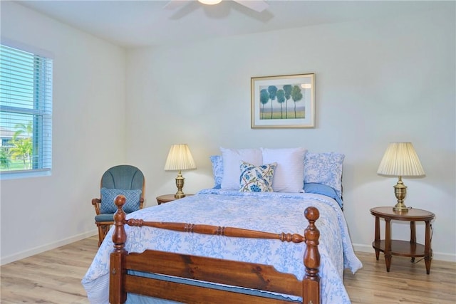 bedroom with a ceiling fan, baseboards, and wood finished floors