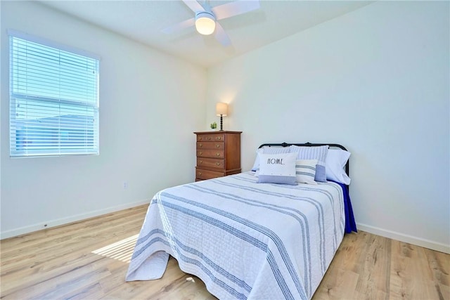 bedroom with a ceiling fan, baseboards, and wood finished floors