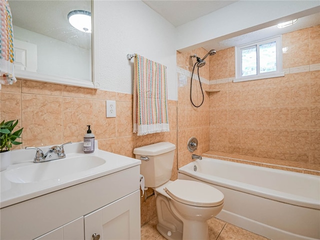 full bathroom featuring tile walls, vanity, tiled shower / bath combo, tile patterned flooring, and toilet