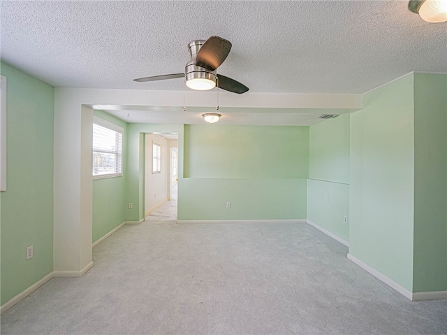 empty room featuring a textured ceiling, light carpet, and ceiling fan