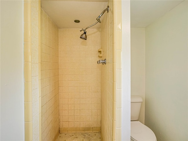 bathroom featuring toilet and a tile shower