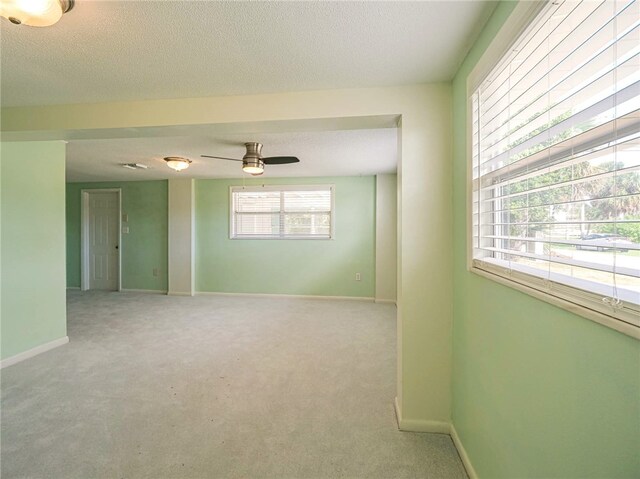 carpeted empty room featuring a textured ceiling and ceiling fan