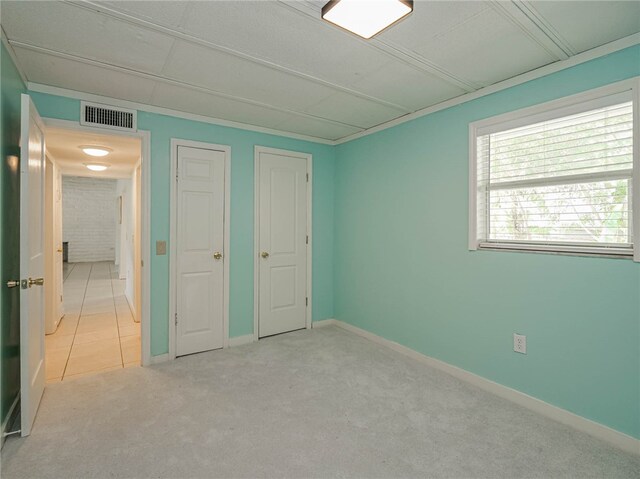 unfurnished bedroom featuring light carpet, a closet, and ornamental molding