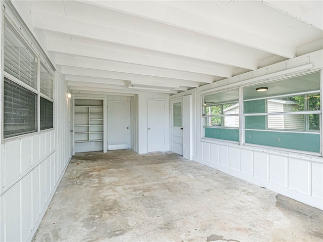 unfurnished sunroom featuring beamed ceiling