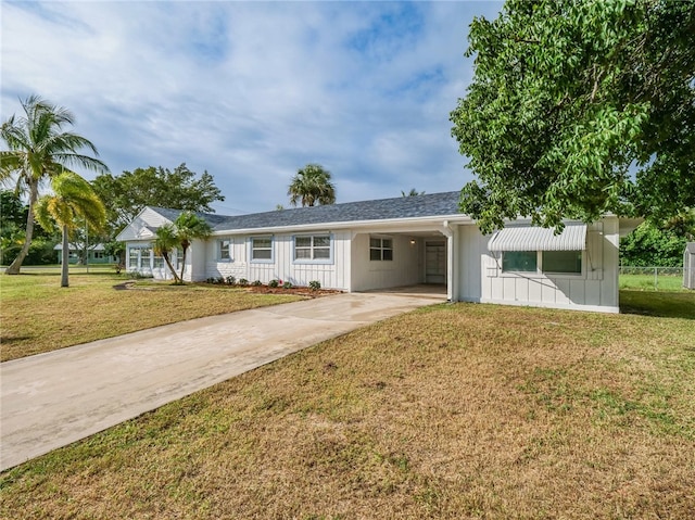 ranch-style house featuring a front lawn and a carport