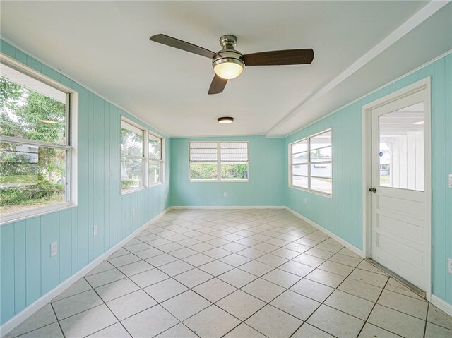 unfurnished sunroom featuring ceiling fan and a healthy amount of sunlight