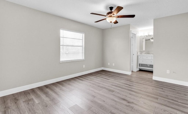 841 Carnation Dr, Sebastian, FL 32958 - unfurnished bedroom featuring wood finished floors, baseboards, ensuite bathroom, and a ceiling fan