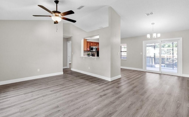 841 Carnation Dr, Sebastian, FL 32958 - unfurnished living room with light wood-style flooring, plenty of natural light, a ceiling fan, a chandelier, and vaulted ceiling
