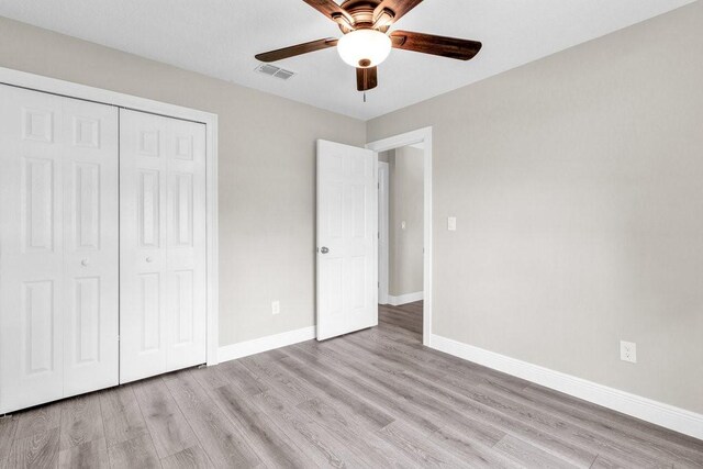 841 Carnation Dr, Sebastian, FL 32958 - unfurnished bedroom with light wood-style floors, baseboards, a closet, and a ceiling fan