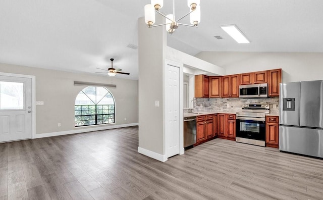 841 Carnation Dr, Sebastian, FL 32958 - kitchen featuring appliances with stainless steel finishes, lofted ceiling, light countertops, light wood-type flooring, and brown cabinets