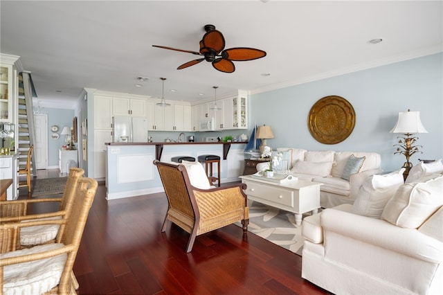 living room featuring ceiling fan, sink, dark hardwood / wood-style flooring, and ornamental molding