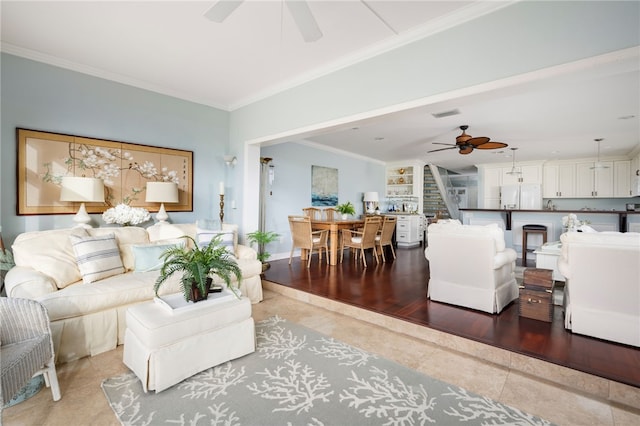 living room featuring ceiling fan, tile patterned flooring, built in features, and crown molding