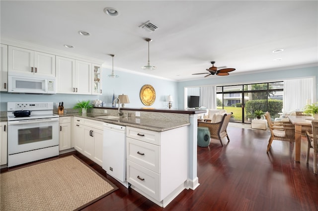 kitchen with kitchen peninsula, sink, white appliances, and pendant lighting