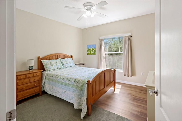 bedroom featuring wood finished floors, a ceiling fan, and baseboards
