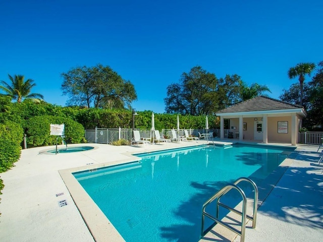 view of pool featuring a hot tub and a patio