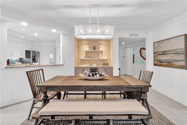 dining space featuring beverage cooler, light tile patterned floors, ornamental molding, and a notable chandelier