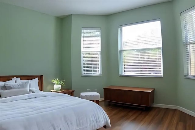 bedroom with hardwood / wood-style flooring and multiple windows