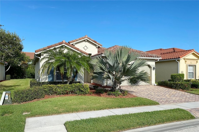 mediterranean / spanish-style home with a front lawn and a garage