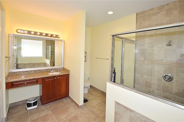 bathroom with tile patterned flooring, vanity, toilet, and a shower with shower door