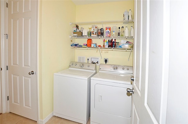 washroom with light tile patterned floors and washing machine and dryer