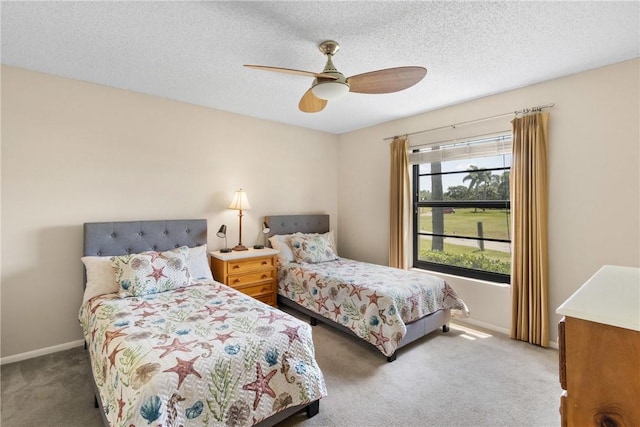 carpeted bedroom featuring baseboards, a ceiling fan, and a textured ceiling