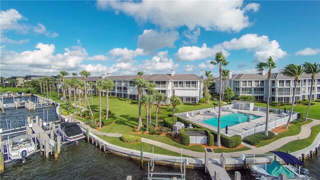 exterior space with a dock, a yard, a patio, and a water view