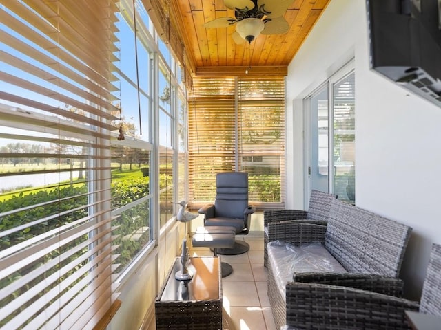 sunroom / solarium featuring ceiling fan, a healthy amount of sunlight, and wood ceiling