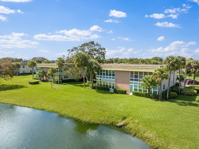 back of house featuring a yard and a water view