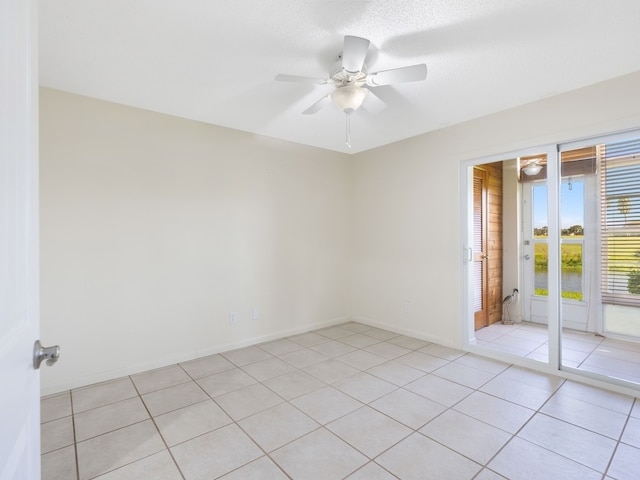 tiled spare room featuring a textured ceiling and ceiling fan