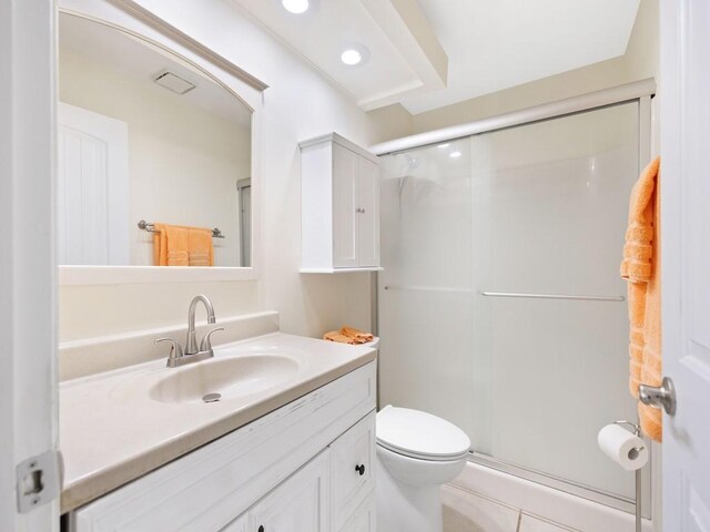 bathroom featuring tile patterned flooring, vanity, toilet, and a shower with door