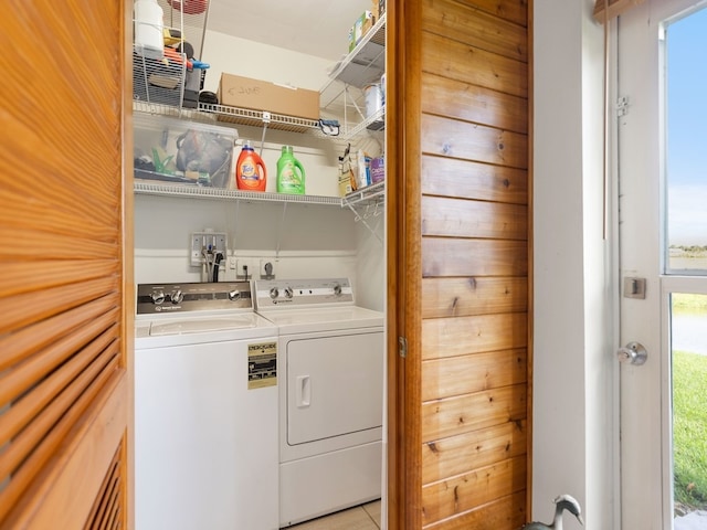 laundry area with washer and clothes dryer and light tile patterned floors