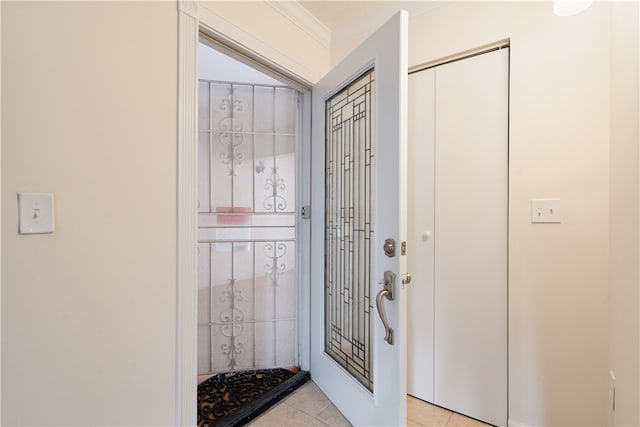 entryway featuring ornamental molding and light tile patterned floors