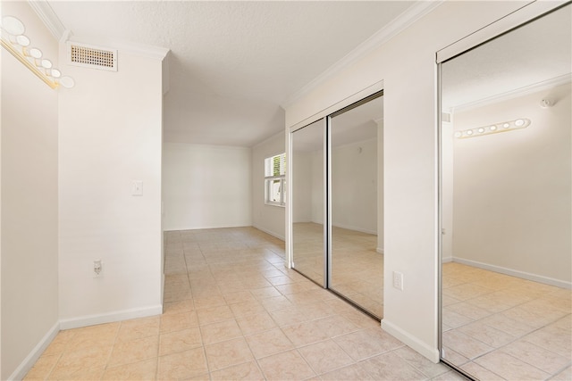 unfurnished bedroom with ornamental molding, a textured ceiling, and light tile patterned floors