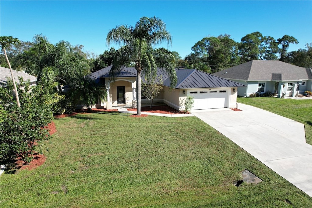 view of front of property featuring a front yard and a garage