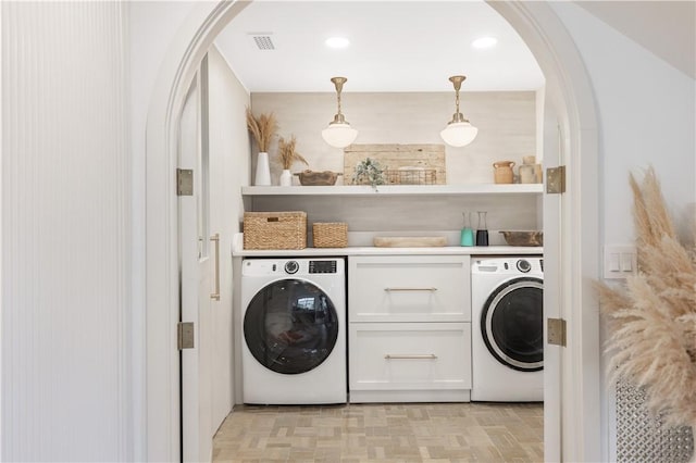 601 Flamevine Ln, Vero Beach, FL 32963 - laundry area featuring washer / dryer, cabinet space, and arched walkways