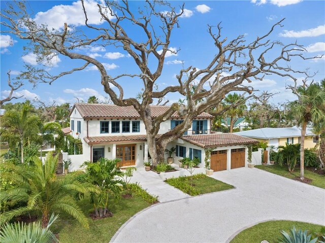 601 Flamevine Ln, Vero Beach, FL 32963 - mediterranean / spanish house with a tile roof, a garage, stucco siding, and driveway