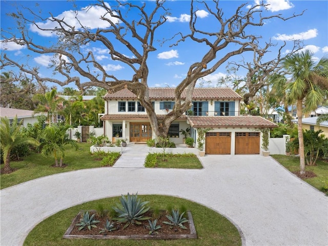 601 Flamevine Ln, Vero Beach, FL 32963 - mediterranean / spanish-style house featuring curved driveway, an attached garage, a tiled roof, and stucco siding