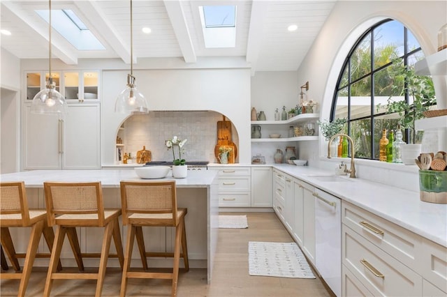 601 Flamevine Ln, Vero Beach, FL 32963 - kitchen with a skylight, open shelves, white dishwasher, tasteful backsplash, and a sink