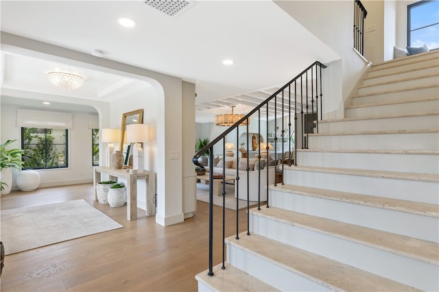 stairway featuring hardwood / wood-style floors and a notable chandelier