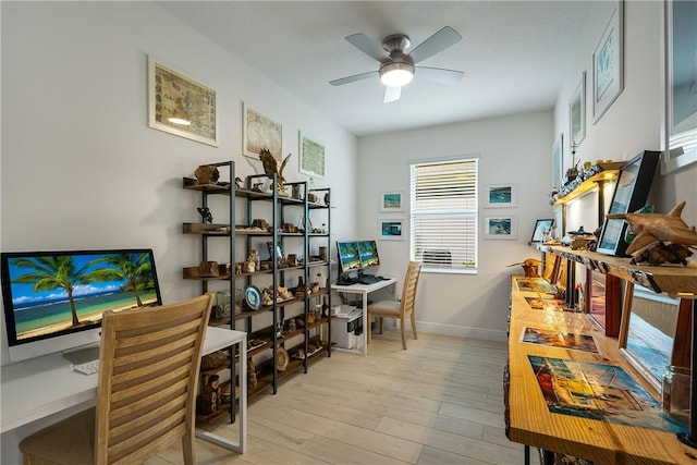 office area featuring ceiling fan, light wood-style flooring, and baseboards